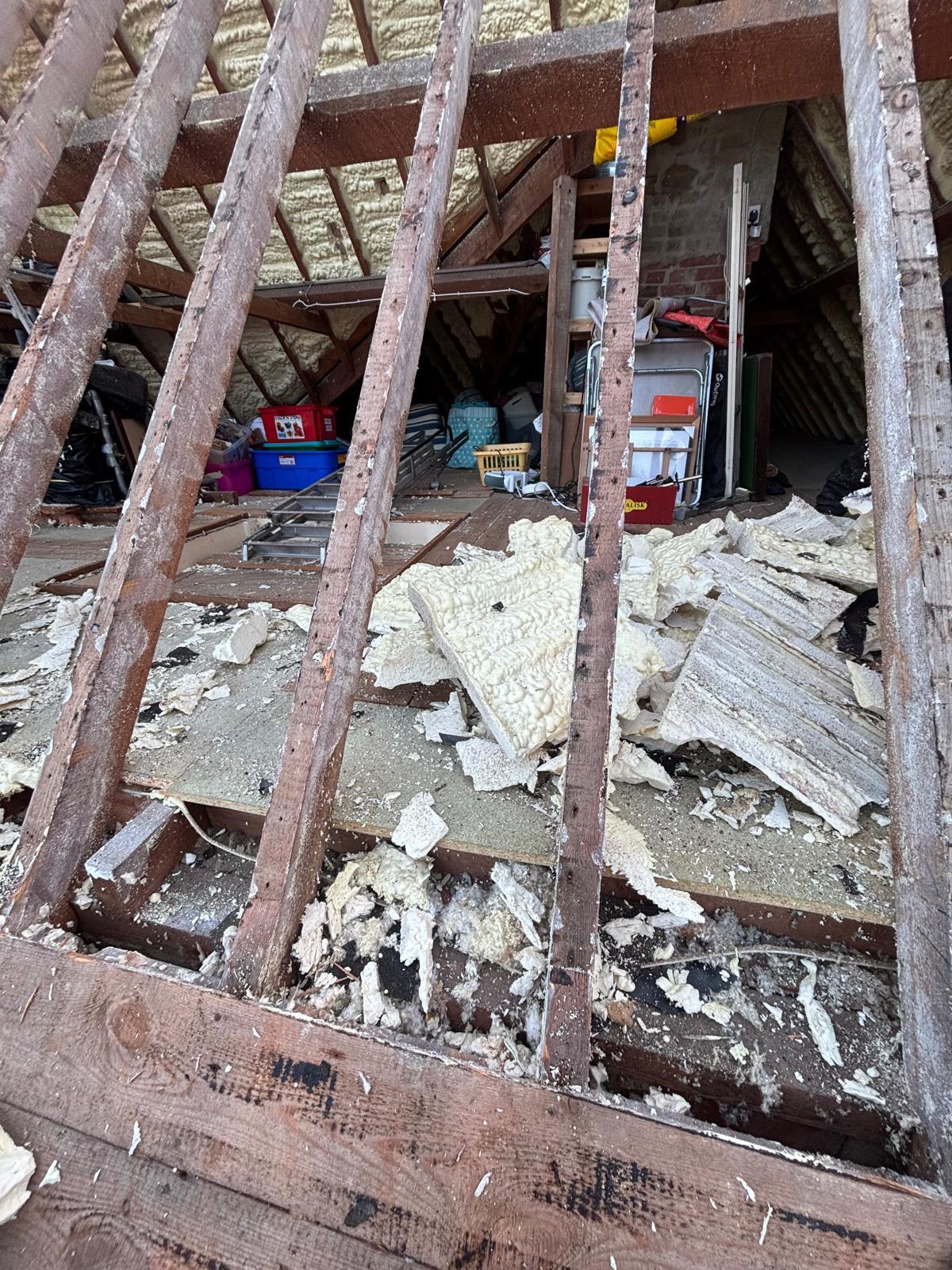 Interior view during strip — old spray foam being safely removed from rafters