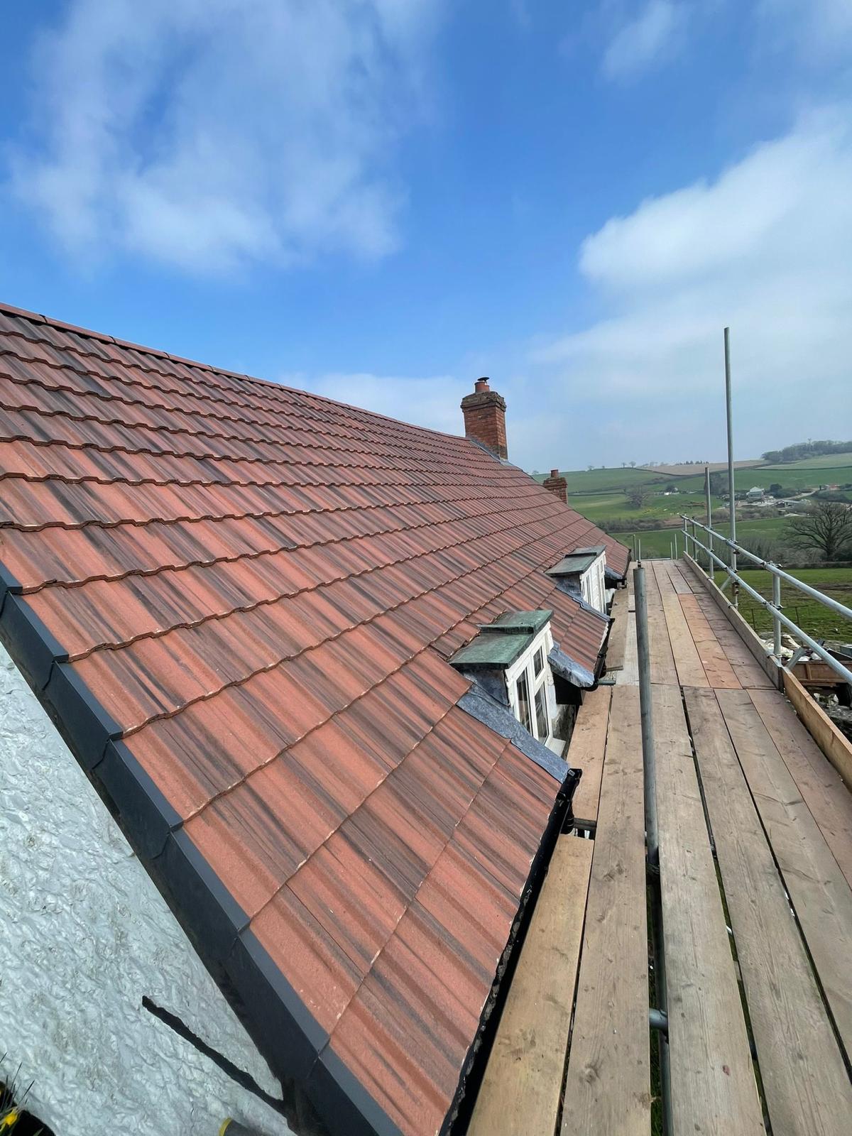 New Redland clay tiled roof with dormer windows and fresh leadwork in Surrey