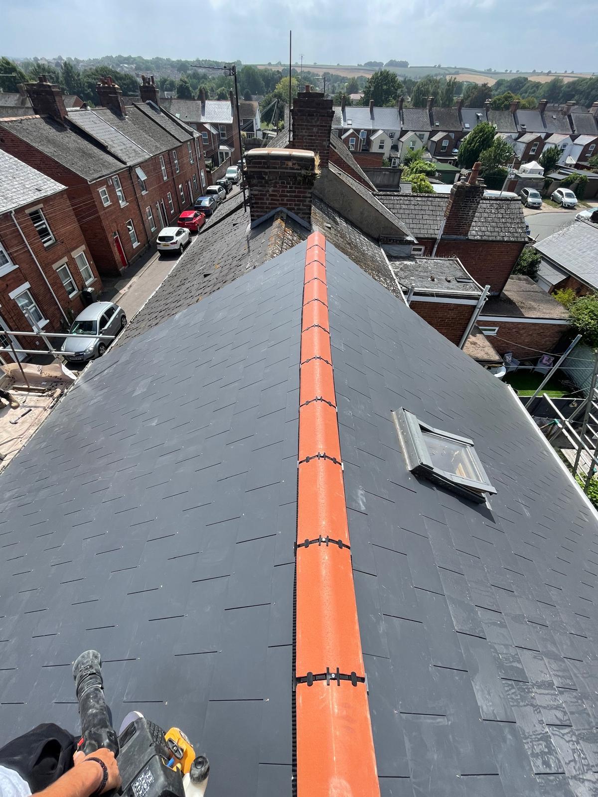 New slate roof with terracotta ridge tiles and skylight