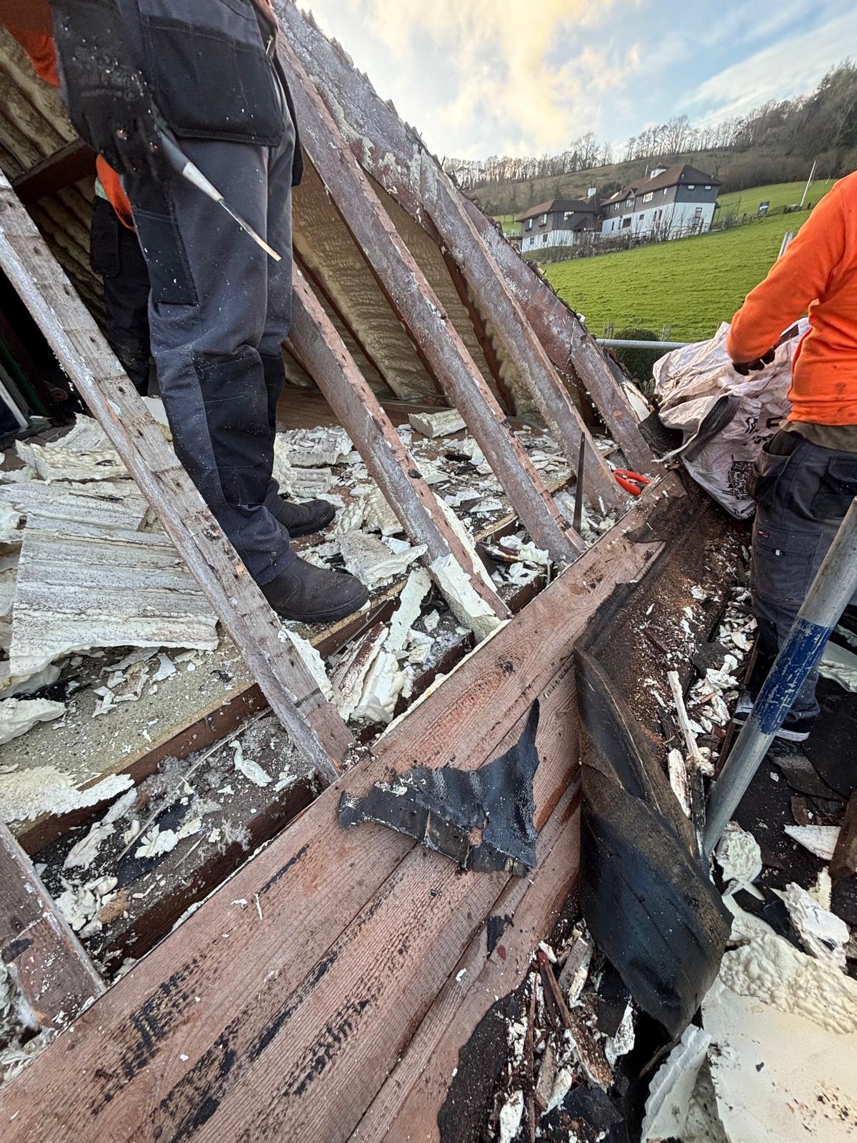 Strip and re-roof in progress — old spray foam and battens removed
