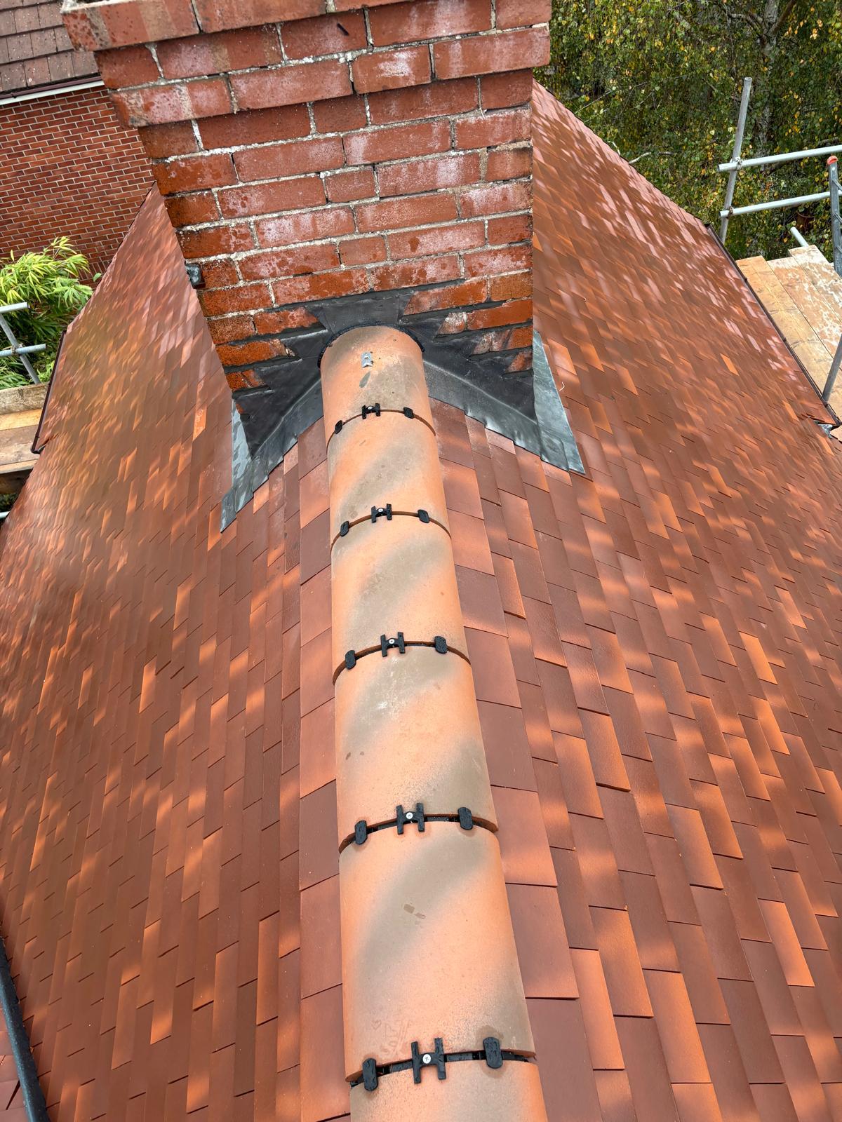New clay tiled roof with fresh lead flashing to chimney