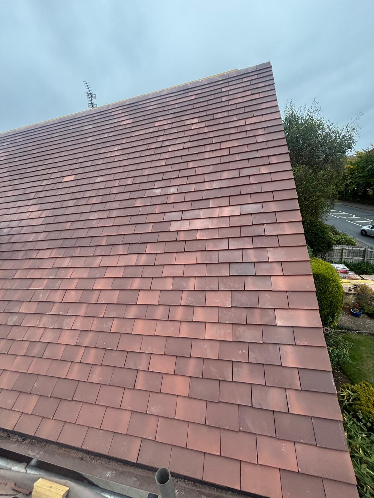 Newly completed red clay plain tile roof — full gable view