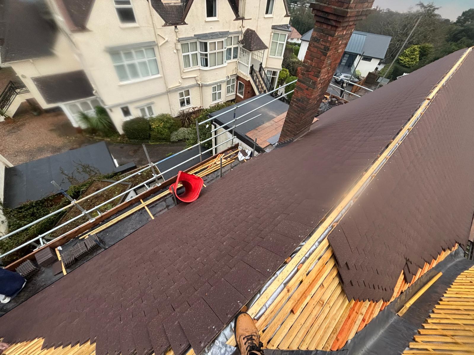 Fresh underlay and battens with new tiles being loaded onto scaffold