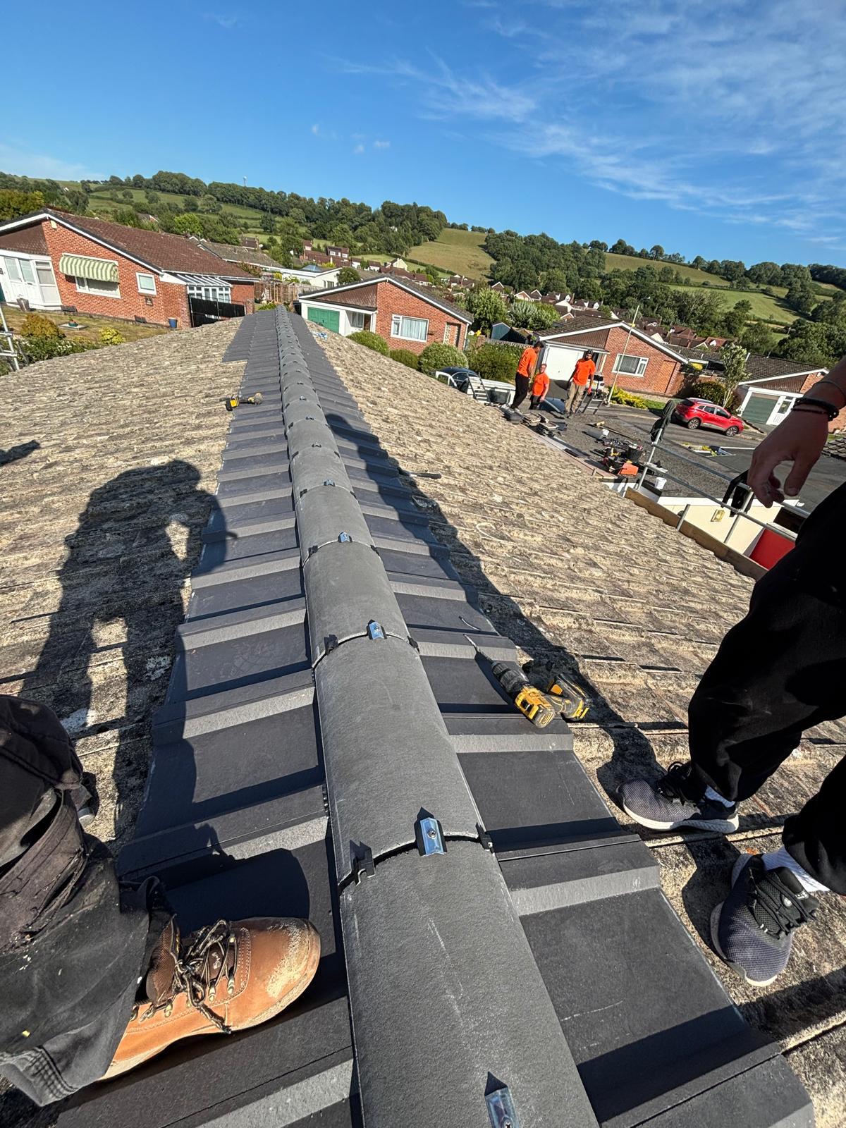 Team fitting dry-fix ridge tiles on a large project
